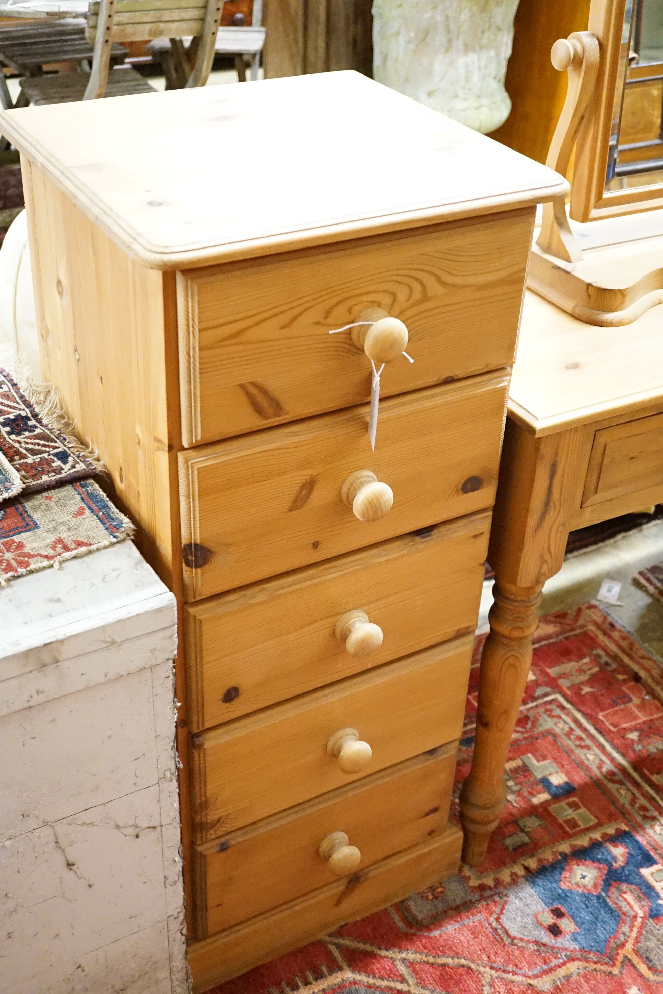 A pine side table, 89cm, a low cabinet, two chests of drawers, a pair of bedside tables, a mirror and jewellery box (8)